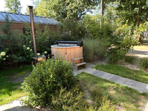 阿纳姆Holiday Home Maridu Wellness的花园内设有一个热水浴缸和长凳