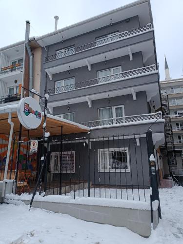 安卡拉Deeps Hostel Ankara 2的雪中一座建筑物,前面有标志
