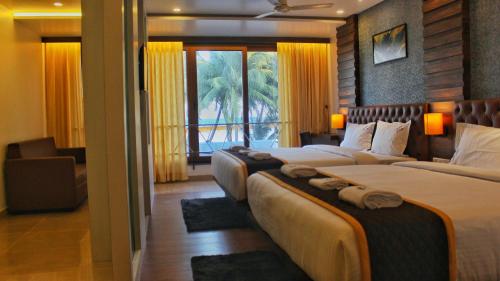 布莱尔港HOTEL IDHAYA的酒店客房设有两张床和窗户。