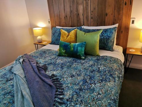里士满The Shoemaker's Cottage的一间卧室配有一张带蓝色和绿色枕头的床