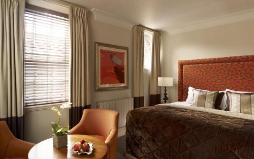 埃文河畔斯特拉特福斯特拉特福阿尔登酒店 - 伊登连锁酒店的卧室配有1张床、1张桌子和1把椅子