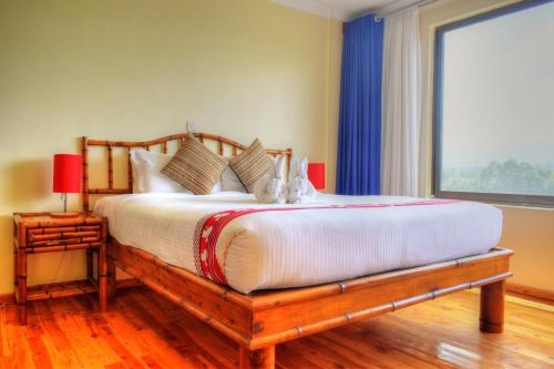 纳纽基Peaks Hotel Nanyuki的一间卧室设有一张大床和大窗户