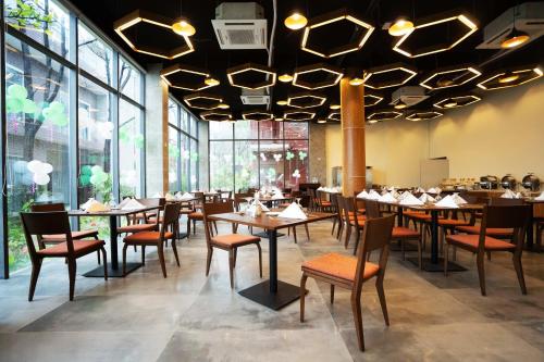 库克斯巴扎DERA Resort & Spa的用餐室配有桌椅和大窗户