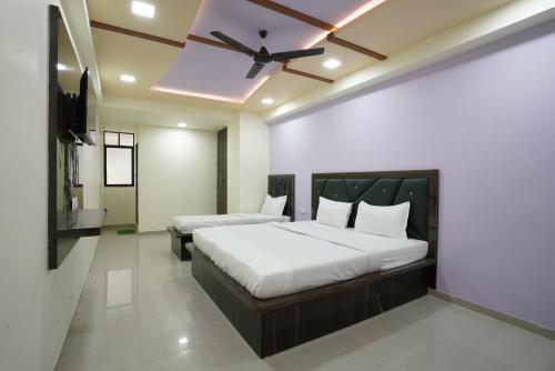艾哈迈达巴德Hotel GGC INN的一间卧室配有两张床和吊扇