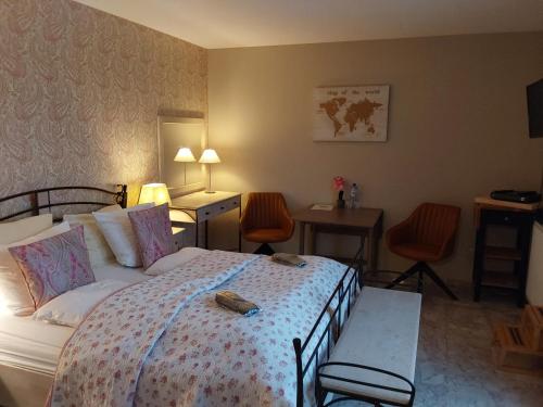 德塞尔金龙酒店 的酒店客房带一张床、一张桌子和椅子