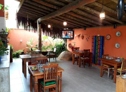 伊利亚贝拉Suítes Cambucá的一间设有木桌和椅子的餐厅