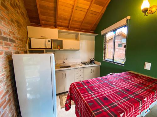 新彼得罗波利斯Vovô Emílio Chalés的厨房设有绿色的墙壁和红色的格子布