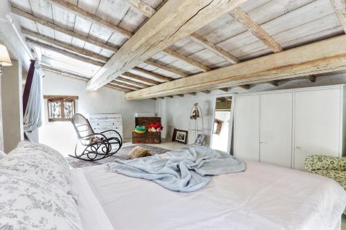奎尔瑟Villa Tramonto的一间卧室配有一张大床和一把椅子