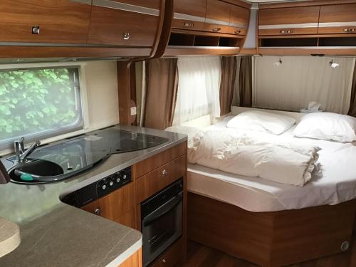 Anglure-sous-DunGezellige luxe caravan met zwembad in zuid- Bourgogne的一间带床和水槽的小厨房