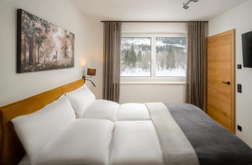 巴德加斯坦Auhof - Apartments Bad Gastein的卧室配有白色的床和窗户。