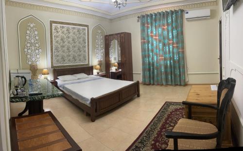 布哈拉Grand Emir Residence的一间卧室配有一张床、一张桌子和一面镜子