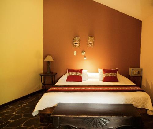 萨拉皮基Sarapiquis Rainforest Lodge的一间卧室设有一张带红色墙壁的大床