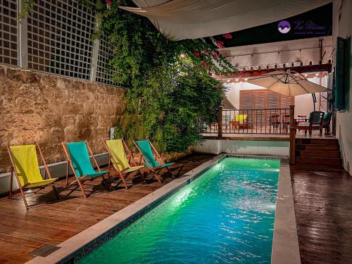 El MînaVia Mina Hotel的一个带椅子和桌子的游泳池
