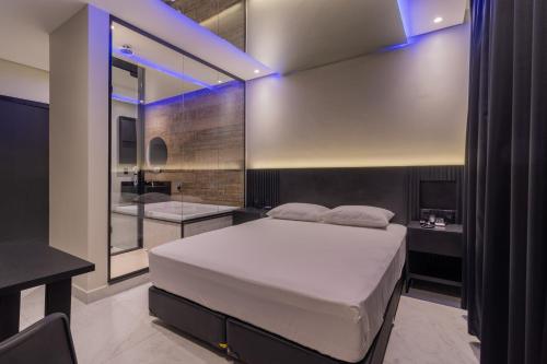 阿雷格里港Drops Motel POA Zona Sul的一间带大床的卧室和一间浴室