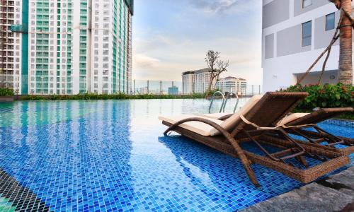胡志明市S'Home Saigon - Infinity Pool Signature的游泳池旁的一把椅子