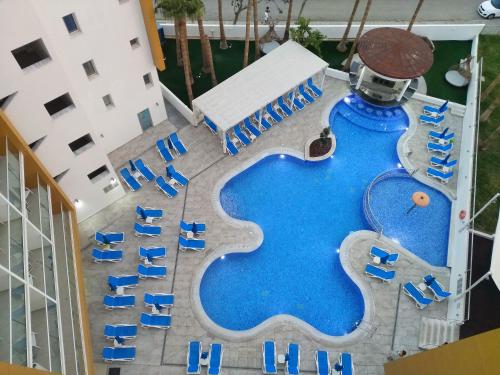 普罗塔拉斯Captain Pier Hotel的享有带蓝色椅子的游泳池的顶部景致