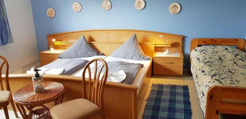 圣彼得奥尔丁Ferienwohnung-Floppy-Hansi-Fewo-4-EG的卧室配有一张床和一张桌子及椅子