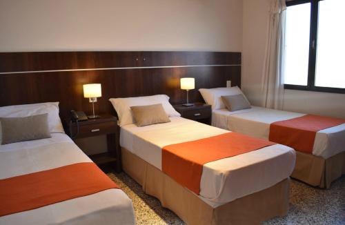 萨尔塔Apartamentos Ref的酒店客房设有两张床和两盏灯。