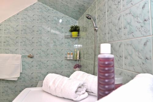 布雷兹诺Apartmán Ivka的带淋浴的浴室和水槽上的一瓶水