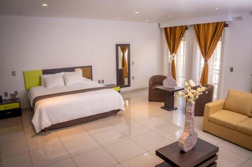 San José IturbideHotel SanJo的一间卧室配有一张大床、一张沙发和一张桌子