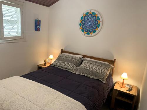坎波斯杜若尔当Chalé da Araucária的一间卧室配有一张带2个床头柜和2盏灯的床。