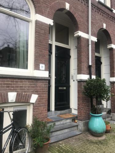 阿姆斯特丹Six的一辆自行车停在砖房外面,有一道黑色的门