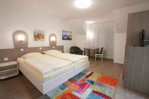 瓦伦霍尔斯特林格曼酒店的一间卧室配有一张床和一张桌子及一台电视