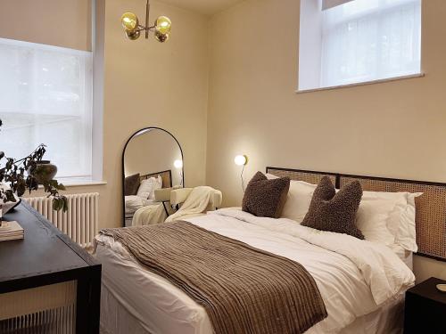 托德莫登Luxury 2 Bedroom Flat in Central Todmorden的一间卧室配有一张大床和镜子