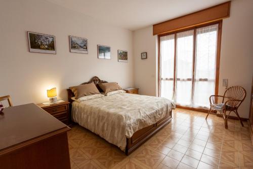 比耶拉Appartamento vista Alpi biellesi的一间卧室配有一张床、一张桌子和一个窗户。
