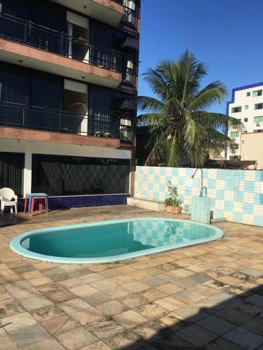 曼加拉蒂巴Itacuruça Palace Hotel的一座小游泳池,位于一座建筑前