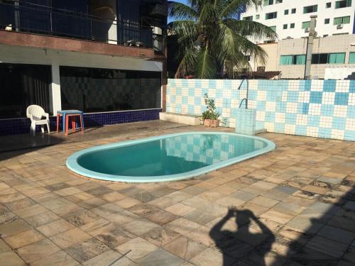 曼加拉蒂巴Itacuruça Palace Hotel的给游泳池拍照的人的影子