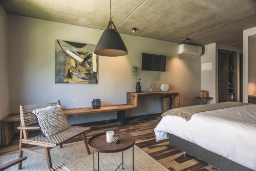 埃斯特角城Be House Suites & Spa by Nobile的卧室配有1张床、1张桌子和1把椅子