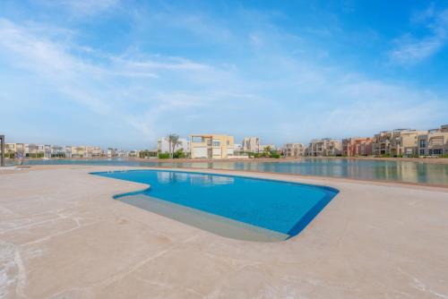 赫尔格达Brand-New Family House in Tawila El Gouna Lagoon and Pool Access的一座拥有建筑背景的游泳池