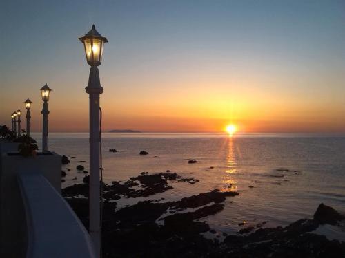 Marine du Miomo阿里亚纳酒店的海洋上的日落,有街灯