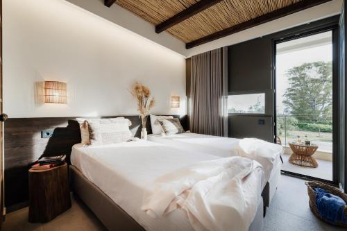 卡纳里奥Suite Homes - Fine Living , Preveza的一间卧室设有两张床和大窗户