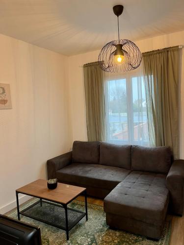 GagnySuper appartement chaleureux à 30min de Paris的客厅配有沙发和桌子