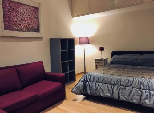 罗马罗马达诺伊套房酒店的一间卧室配有一张床和一张沙发