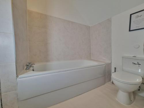 伦敦Lovely Large London Apartment Near Stratford的浴室配有白色浴缸和卫生间。