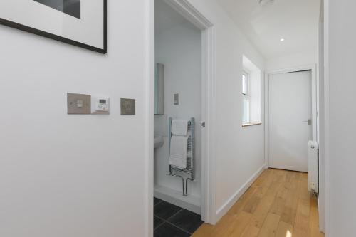 彭赞斯15 Boscaswell Downs的浴室设有白色的墙壁和镜子