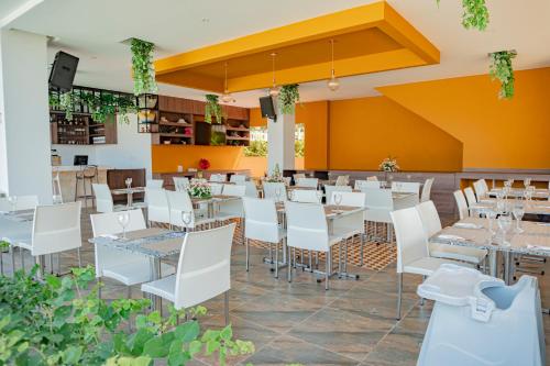 TubaráHotel Explore Caño Dulce的一间设有白色桌子和白色椅子的餐厅