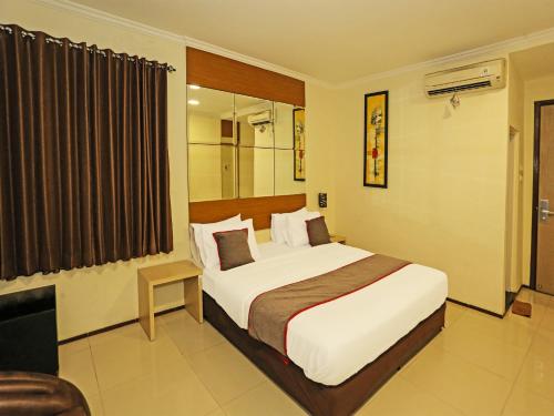 塞尔蓬Super OYO Townhouse OAK Hotel Fiducia Serpong的酒店客房,配有床和电视