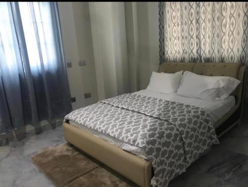 SpintexAdonai Luxury Apartments Accra的一间卧室配有一张带木制床头板的床