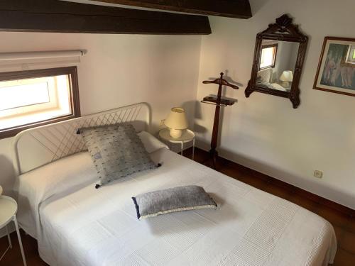 滨海比拉萨尔Apartament Cal Negre的卧室配有白色床,墙上有十字架