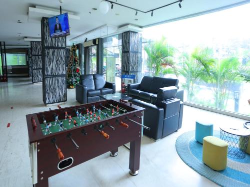 雅加达Super OYO Townhouse OAK Hotel Fiducia Pondok Gede的客厅设有桌上足球和沙发。