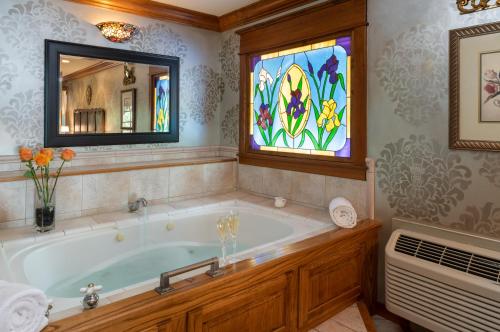 尤里卡斯普林斯Angel at Rose Hall的带浴缸的浴室和彩色玻璃窗