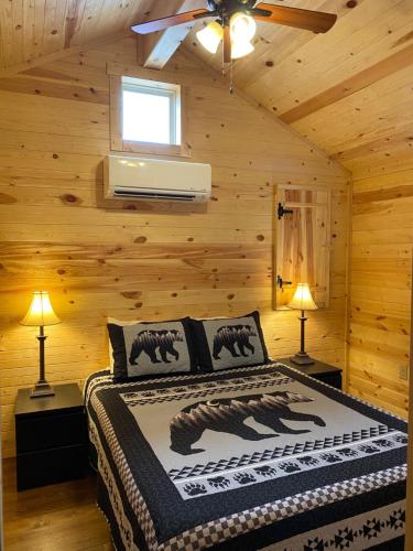 赛维尔维尔Smoky Hollow Outdoor Resort - Log Cabin的小木屋内一间卧室,配有一张床