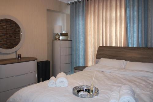 索利赫尔Stylish 4-Bedroom House near NEC/BHX的酒店客房,配有带毛巾的床和碗