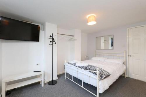 HillsboroughSpacious 2 Bed, Free Parking, Free Wifi - Serene Homes Sheffield的一间卧室配有一张床和一台平面电视