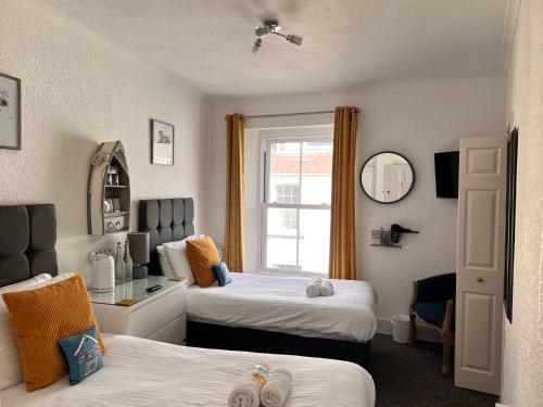 滕比Gumfreston Guest House的酒店客房设有两张床和窗户。