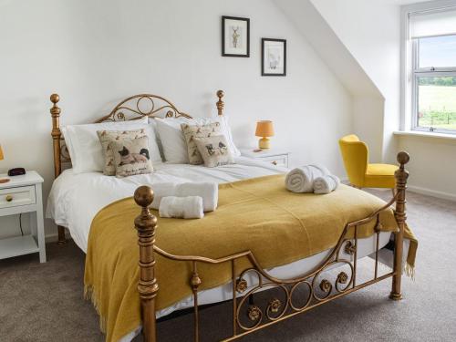 WhitsomeThe End Hoose的一间卧室配有一张大床和一张黄色椅子